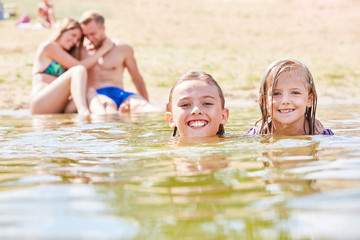 Geschwister schwimmen zusammen im Meer