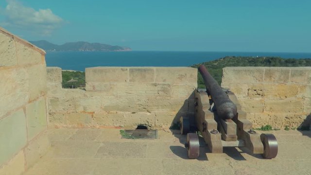 A view of an artillery weapon at top of the castell cala millor, sa coma, dominating the bay and a large part of the island of Mallorca.