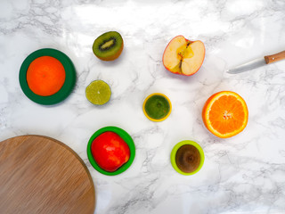 Sliced fruits with colorful reusable silicone food wraps for reducing food waste and food loss in a zero waste lifestyle