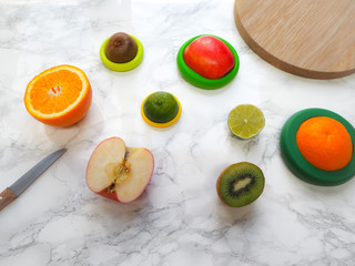 Sliced fruits with colorful reusable silicone food wraps for reducing food waste and food loss in a zero waste lifestyle