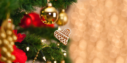 Fototapeta na wymiar Christmas gingerbread decoration on a christmas tree. Background of de-focused lights. Christmas decoration on christmas tree. Winter holidays. Copy space