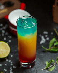 rainbow cocktail with ice on the table