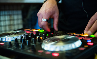 Fototapeta na wymiar DJ Hands creating and regulating music on dj console mixer in concert nightclub stage.