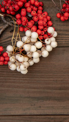 white and red Rowan branch on a wooden background.