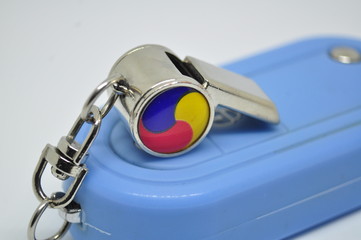 closeup of a whistle on car key background
