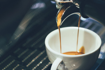 Closeup of pump driven espresso machine and portafilter brewing by forcing pressurized water...