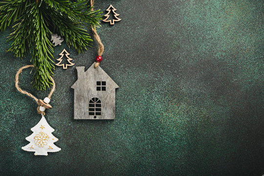 Festive background with toy wooden house christmas tree and decoration. Copy space, winter holidays greeting card, flat lay, top view.
