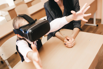 Children with virtual reality glasses are in the school office. Modern teaching methods