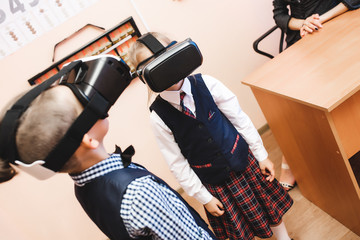 Children with virtual reality glasses are in the school office. Modern teaching methods