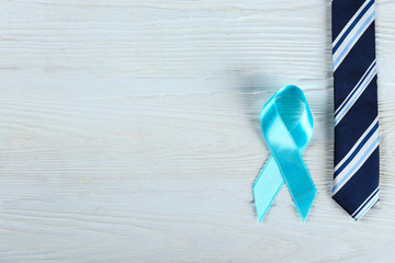 Blue awareness ribbon - symbol for fighting prostate cancer, support the survivors and child abuse awareness. Isolated on white background, copy space, close up, top view, flat lay.