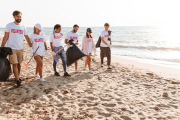 Image of multinational eco volunteers cleaning beach