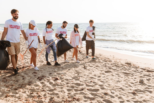 Image of multinational eco volunteers cleaning beach