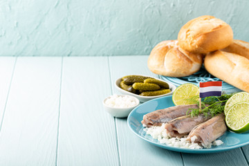Freshly salted herring fish, traditional dutch delicacy called hollandse nieuwe on turquoise plate...