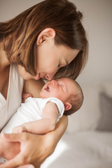Cute newborn baby sleeping in mother's arms. Motherhood.