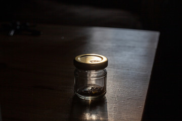 A small jar for storing spices. The can is standing on the table. Minimalistic still life.