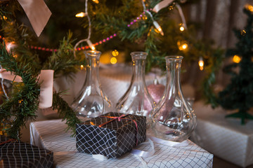 Christmas toys, garlands and interior elements in lights, home decoration for the holiday. Tied cinnamon sticks, kerosene lamp, glowing stars, lights in the side.