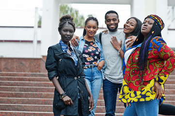 Fototapeta premium Grupa pięciu afrykańskich studentów spędzających razem czas na terenie kampusu uniwersyteckiego. Czarni przyjaciele afro studiują. Motyw edukacji.