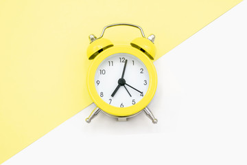 Yellow clock on yellow and white background