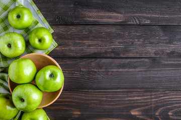 Ripe green apples and apple slices on old wooden background.Vegetables for diet and healthy eating.Organic food. Place for text. Top view