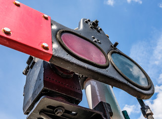 Close-up, shallow focus view of a vintage railway signalling system showing the coloured glass,...
