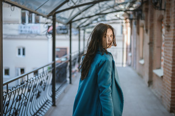 City portrait of beautiful young woman in coat.