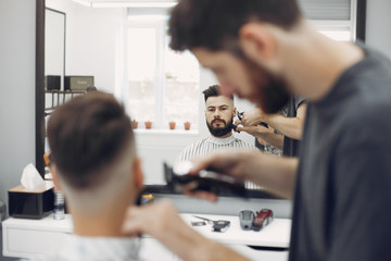 Man with a beard. Hairdresser with a client. Brunette in a barbershop