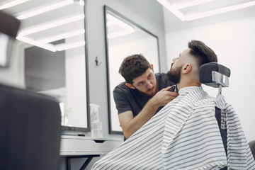 Obraz premium Man with a beard. Hairdresser with a client. Brunette in a barbershop