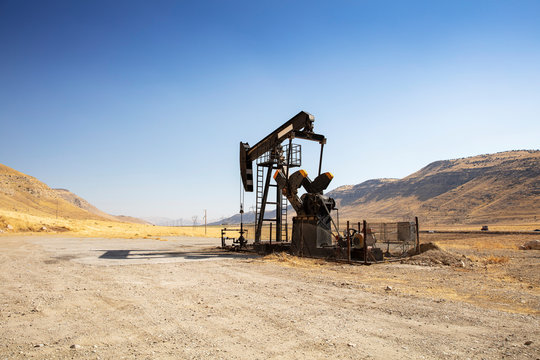 Oil Drilling Derricks At Desert Oilfield. Crude Oil Production From The Ground. Oilfield Services Contractor. Oil Drill Rig And Pump Jack. Petroleum Production, Natural Gas, Liquids, NGL, Additive.