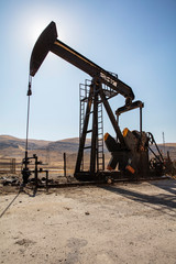 Oil drilling derricks at desert oilfield. Crude oil production from the ground. Oilfield services...