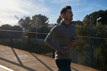Man running next to a fence on a road