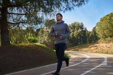 Young man running passed a tree