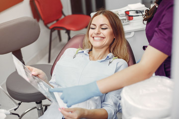 Obraz premium Beautiful lady in the dentist's office. Woman in a purple uniform