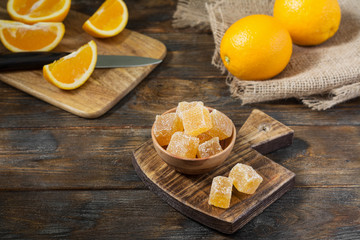 Marmalade sprinkle with sugar in a wooden bowl on a wooden table	