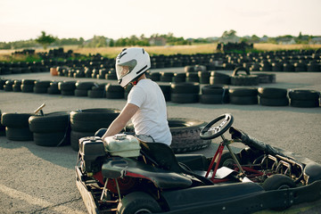 Karting. Man in a white t-shirt. Male with a kart car - obrazy, fototapety, plakaty