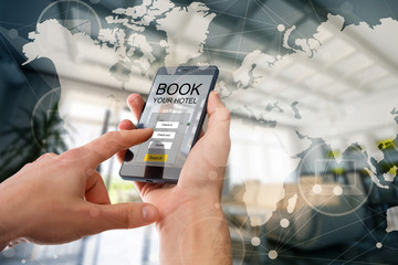 holding a smartphone with booking hotel room app on screen world map