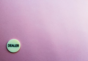 Chip dealer lies in the cner on a pink background. T he game of poker. Place for text. Gambling.