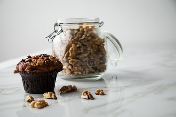 Walnuss Muffin und Nüsse in Bügel Glas auf hell Marmor Tisch Hintergrund