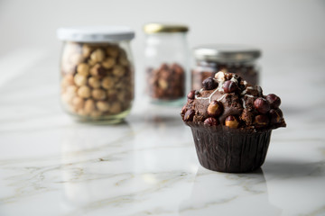 Haselnuss Muffin mit  Walnüssen und Haselnüssen in Vorrat Gläser auf Marmor Tisch hell Hintergrund