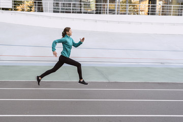 Young adult athletic woman running outdoor in city