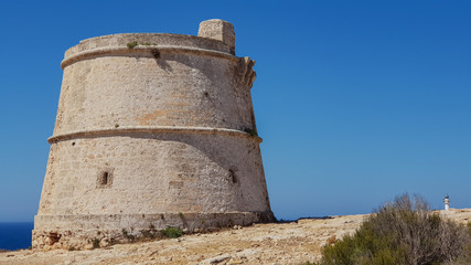 Fototapeta na wymiar Old defense tower: Torre del cap de Barbaria, in the distance Far del cap de Barbaria, Formentera