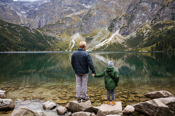 Son and father look at the lake in Tatra National Park, Poland. Small Mountains Lake 'Morskie Oko' In  Morning. © igor_kravtsov