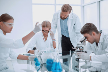 group of scientists and doctors sitting at a laboratory table
