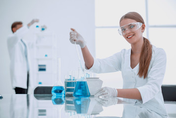 young lab technician sitting at a table in the lab.