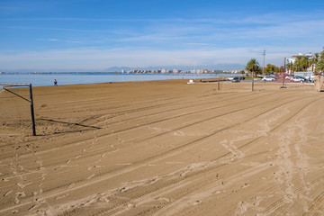Playground for playing beach soccer in Roses, Catalunya, Spain. Empty beach on a sunny day on the sea and blue sky background. Traces of car tires in the sand. Preparing the beach for the game.
