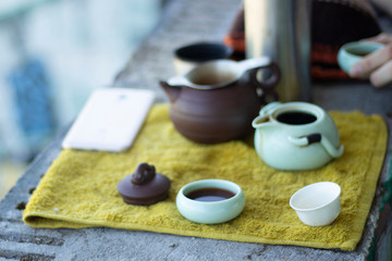 Chinese tea ceremony in the open air. Green tea in the morning. Chinese tea set. Tea pot and cups on a towel. ....