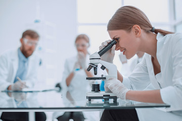 female scientist using a microscope in a chemical laboratory