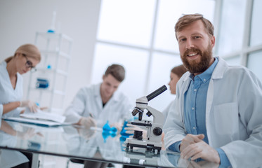 successful young scientist sitting at his Desk in the laboratory