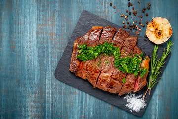 Roast sliced beef Steak medium rare Striploin with chimichurri sauce close up
