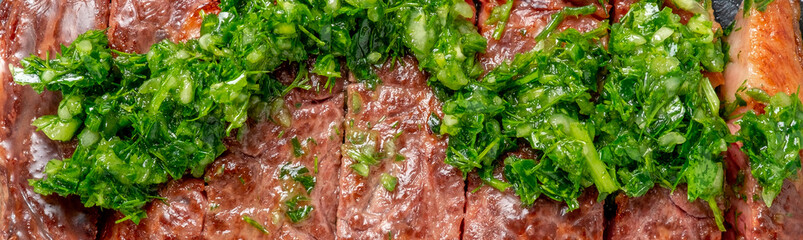 Roast sliced beef Steak medium rare Striploin with chimichurri sauce close up