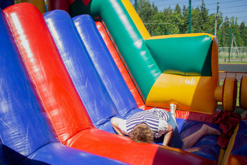 Rubber inflatable slide from an amusement park. The woman went through a sports obstacle course and fell. Entertainment for children trampoline structures from aerial structures.